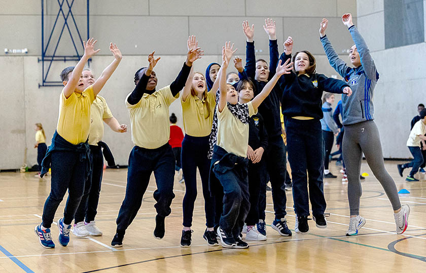 School children at the MIC GAA Centre of Excellence launch, jumping up and reaching for the ball.