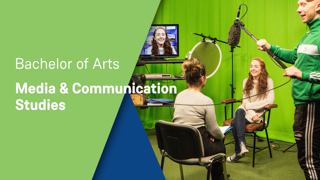 Two female students and one male student are pictured in a TV studio. There is a green screen, TV screen and microphones.