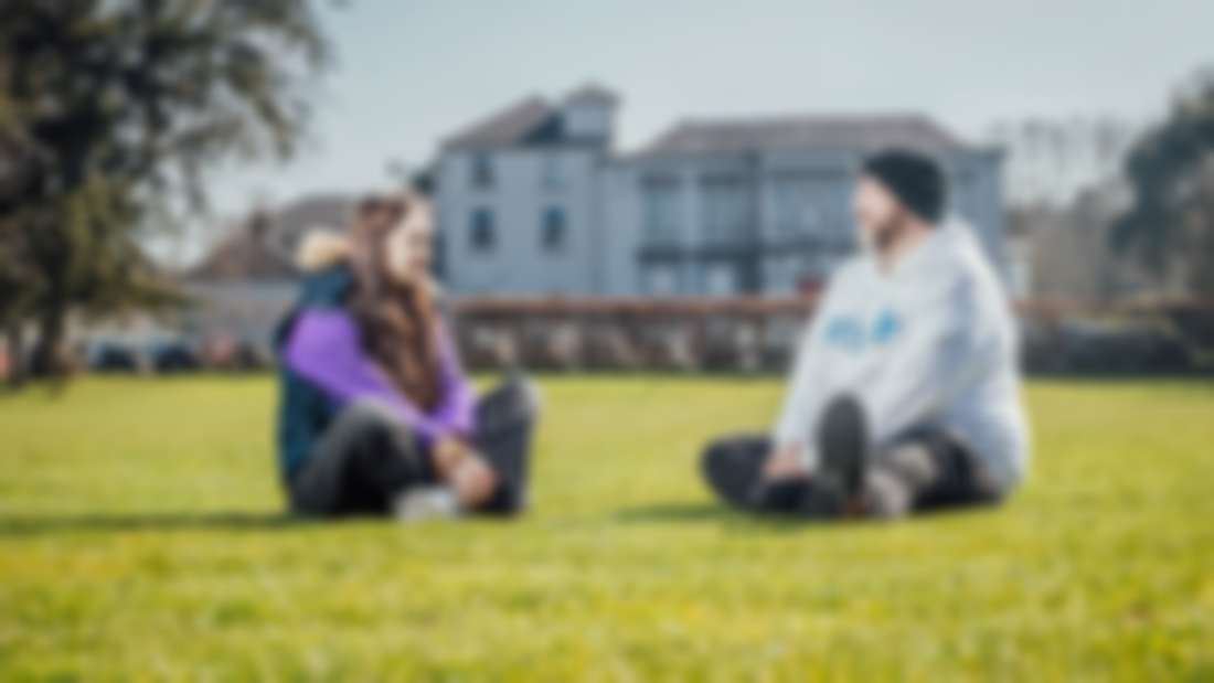 Two students sitting on the green