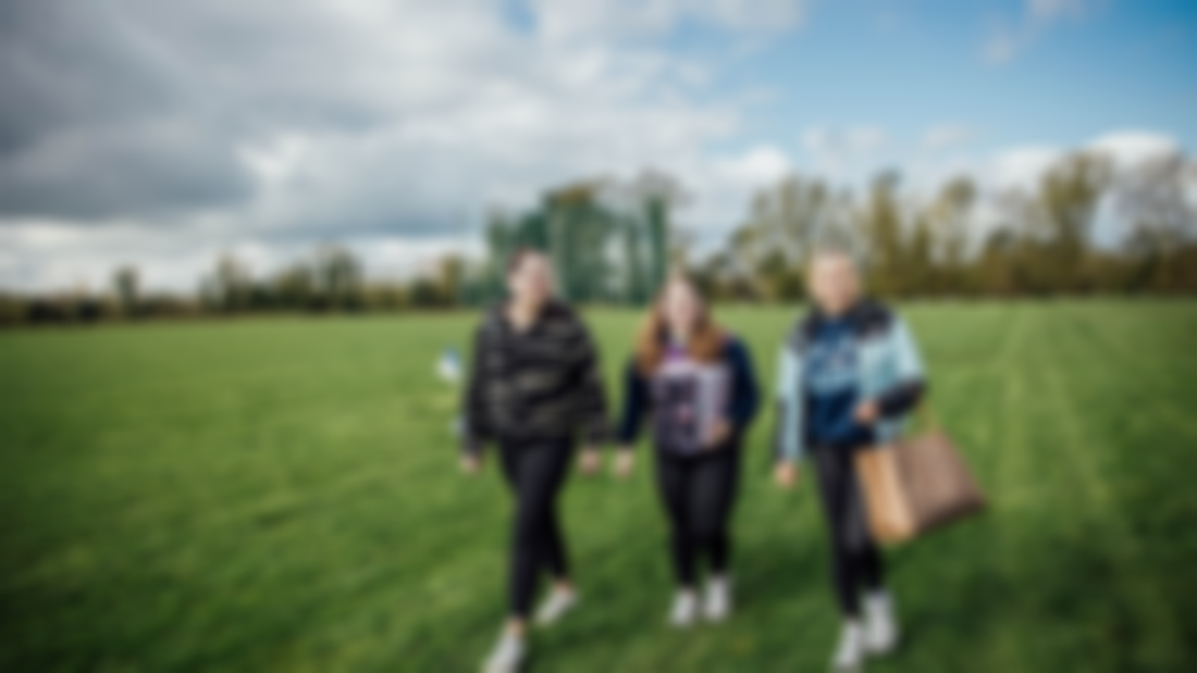 Three students walking next to the GAA pitch in MIC Thurles