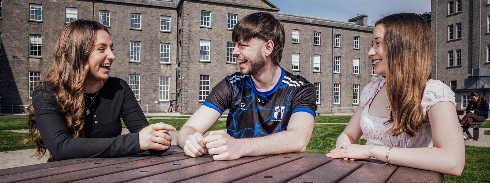 Three students conversing in the Thurles campus quad.