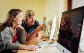 MIC students looking at a computer monitor 