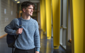 Male student smiling and looking into the distance 