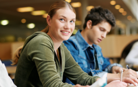 Woman and man sitting in a library studying 