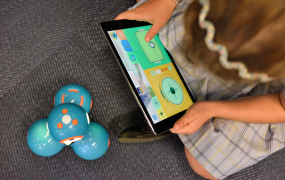 Child sitting on floor playing on an iPad