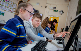 Teacher and student looking at a computer screen