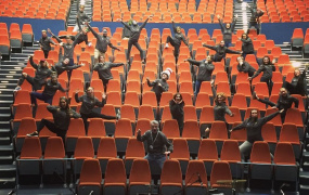 Members of MIDAS standing on seats in Limetree Theatre