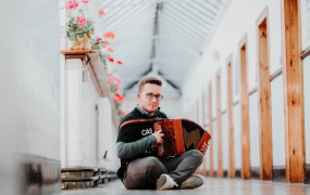 Student with accordion sitting in corridor