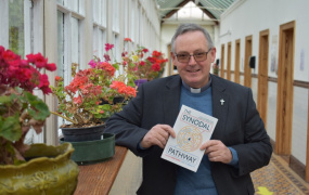 Professor Eamonn Conway in a corridor holding a copy of his book