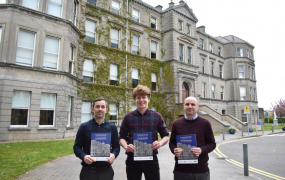 The authors holding copies of the book in front of MIC's Foundation Building