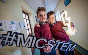 Two primary children holding a STEM sign