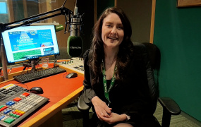 Graduate Fiona Cahill sitting in a radio studio and looking at the camera