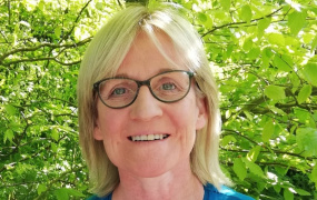 Dr Catherine Stapleton pictured in front of green leaves