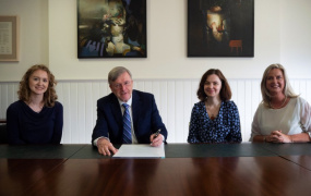  Laura Austin, HEA; Professor Eugene Wall, President of MIC; Dr Jennie Rothwell, HEA; Professor Lorraine McIlrath, Director of EDII at MIC sitting at a table. Professor Wall is signing the principles