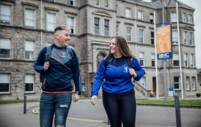 Male and female student talking in front of MIC building