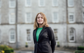 Dr Hannagh McGinley standing in front of a campus building