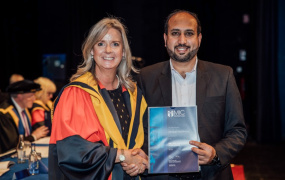 Professor Lorraine McIlrath in ceremonial robes presenting Zimarai with his certificate in recognition of his award