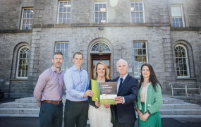 People standing with the report outside the college.