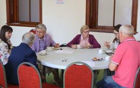 A group of people around a table having tea at an age-friendly event