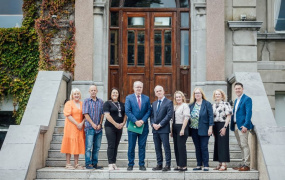 Group of people standing on the steps of a building and posing for a photo