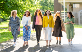 Six women involved with the PATH 1 Symposium walking towards the photographer