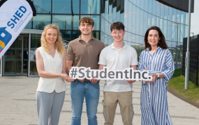 Two students entrepreneurs pose for a photo with two female college officials