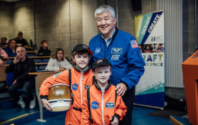 picture of two boys with former astronaut 