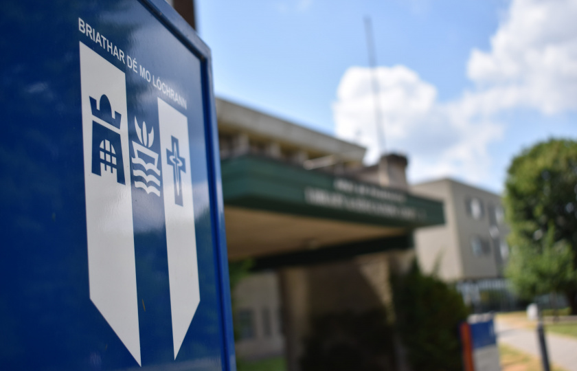 Image of the MIC crest in front of College buildings