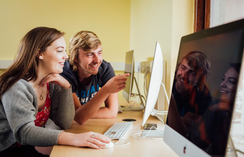 MIC students looking at a computer monitor 