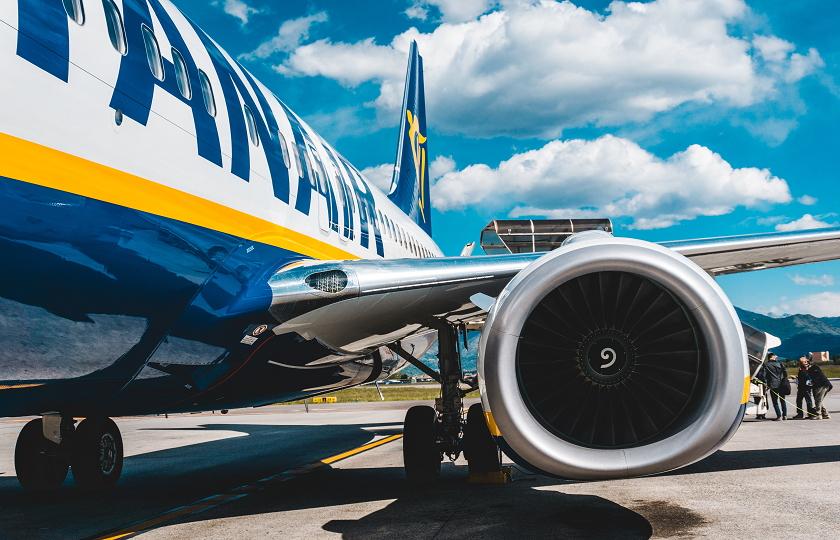 Ryanair plane parked in airport with people boarding 