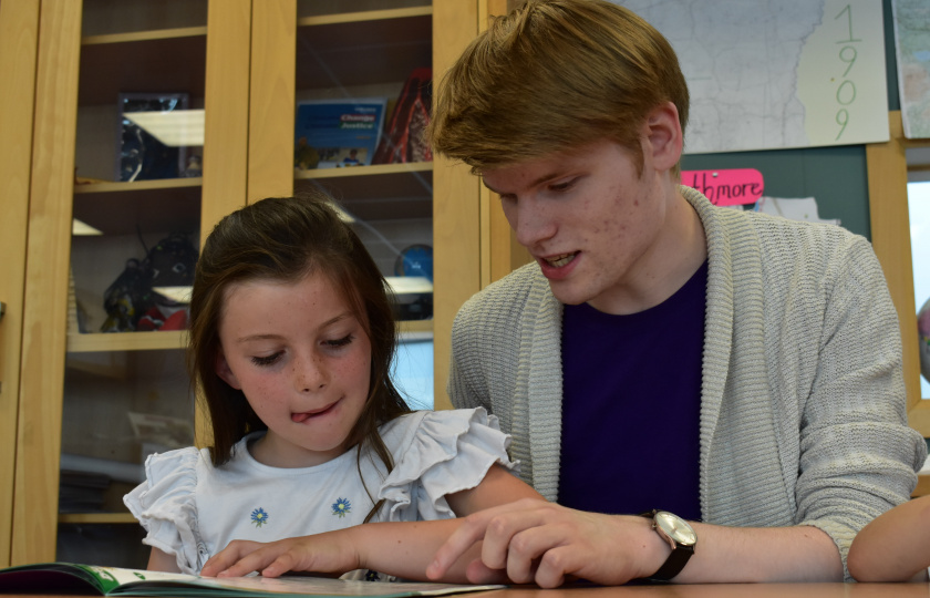 Man and girl reading from a book