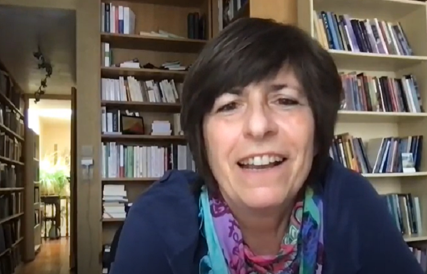 Catherine Maignant pictured in front of two large shelves of books