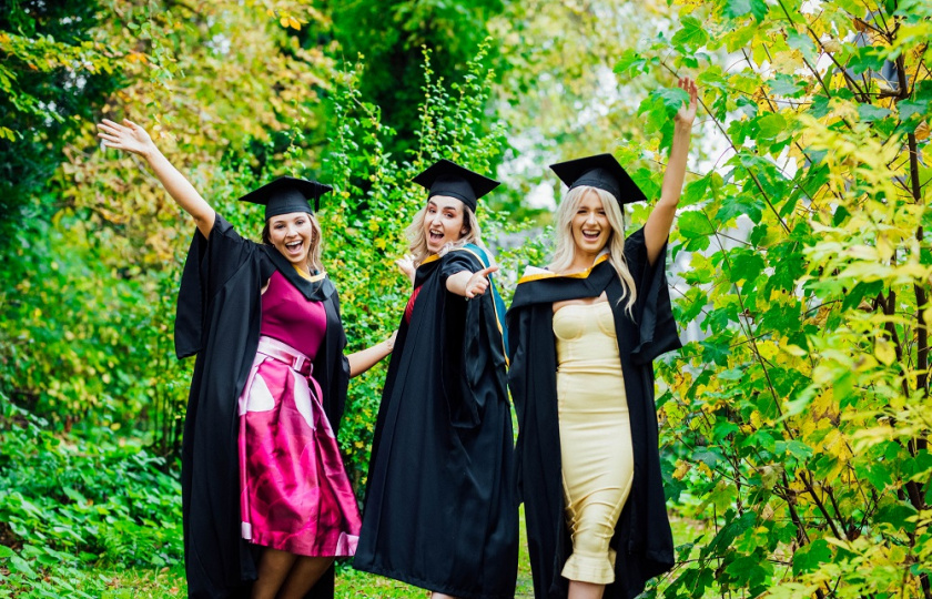 Three female graduating students in their robes