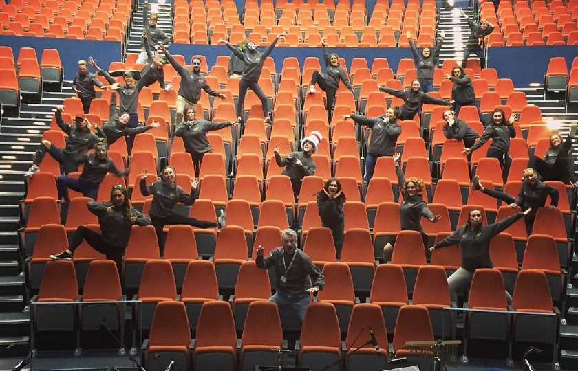 Members of MIDAS standing on seats in Limetree Theatre