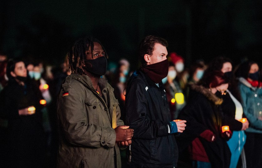 Two people in the crowd holding candles