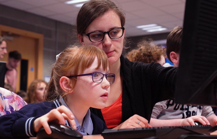 Teacher and student in front of computer screen