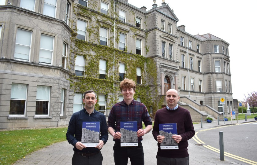 The authors holding copies of the book in front of MIC's Foundation Building