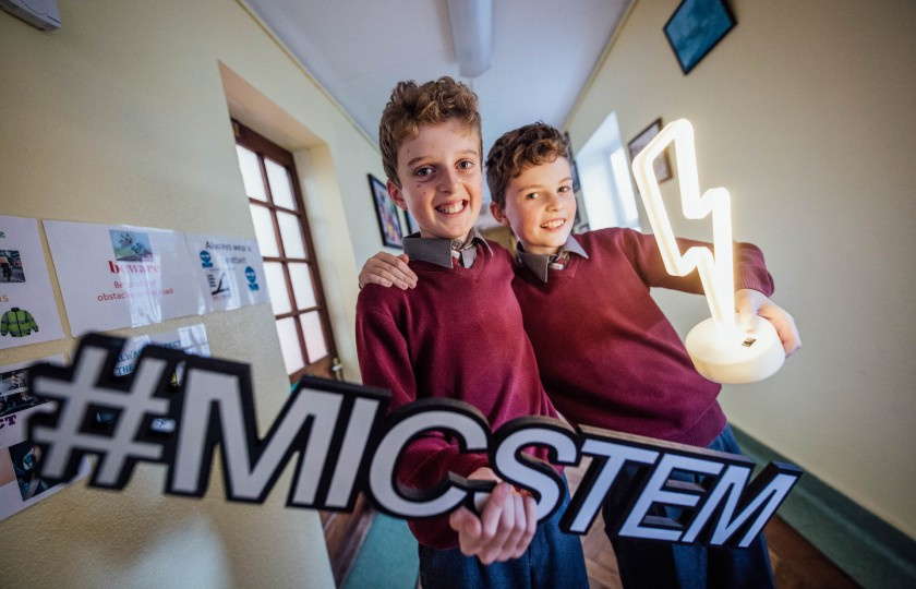Two primary children holding a STEM sign