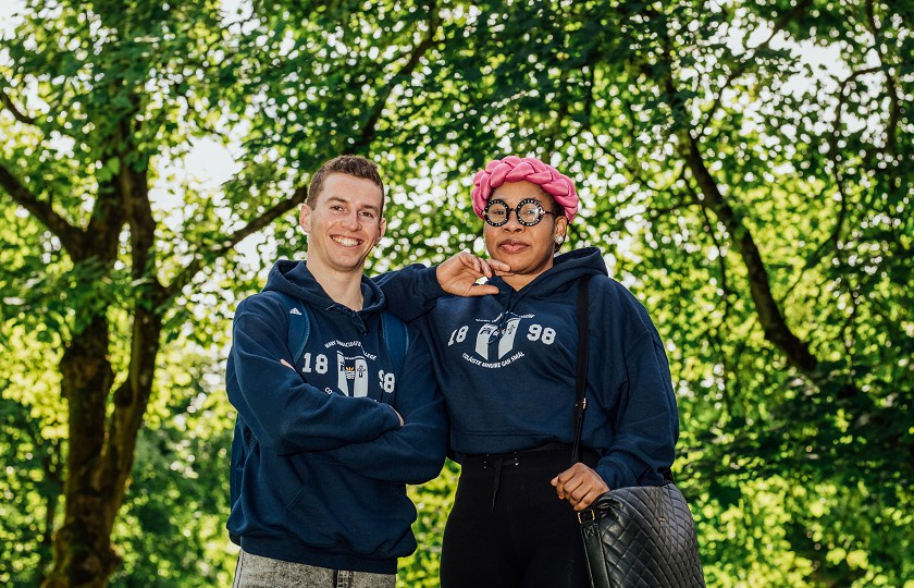 Two MIC students standing in front of trees