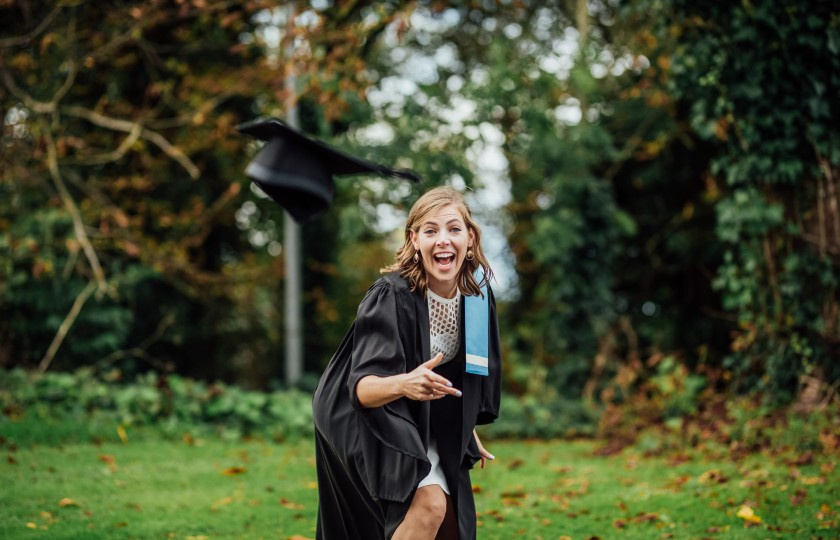 Student throwing hat at camera