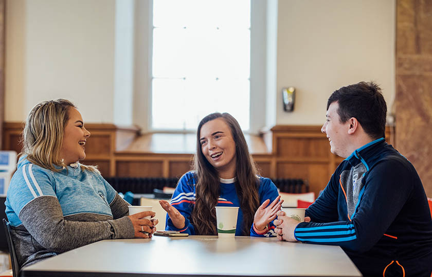 Three students in the MIC Thurles college restaurant, having coffee and chatting.