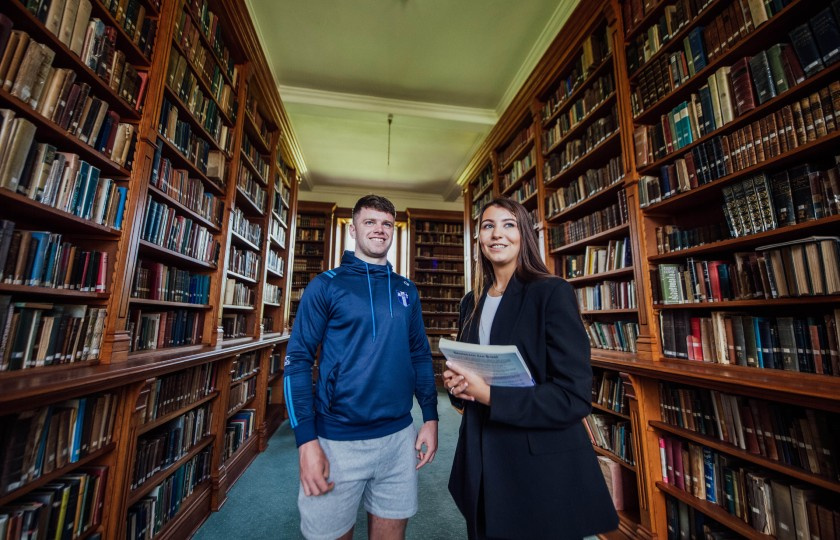 Male and female student standing in MIC Thurles library