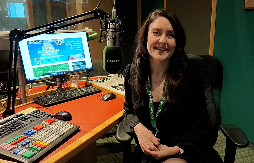 Graduate Fiona Cahill sitting in a radio studio and looking at the camera.