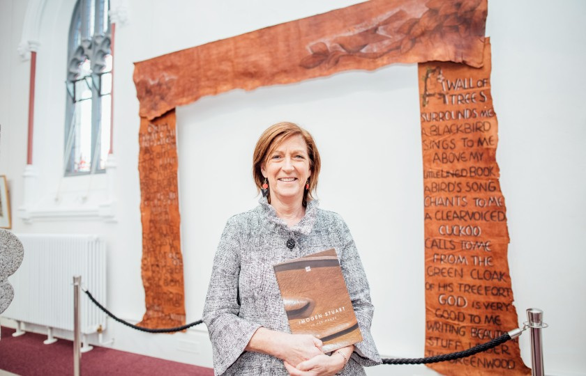 Exhibition Curator Naomi O'Nolan holding an exhibition catalogue at the solo exhibition of Imogen Stuart at MIC Limerick.