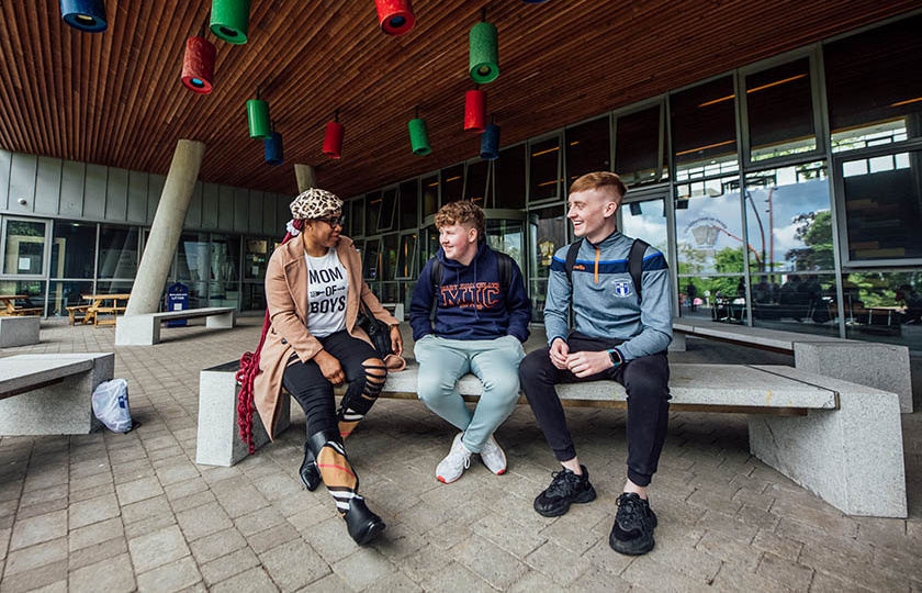 Students sitting outside Tara building at MIC Limerick campus.