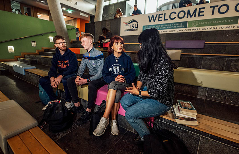 Student sitting on the steps in Tara building at MIC Limerick campus