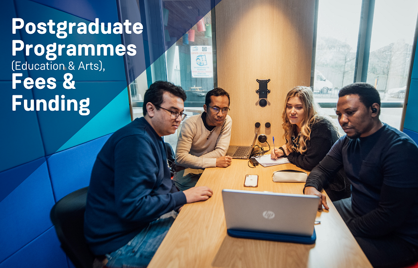 Four Postgraduate students sitting at a desk looking at an open laptop.