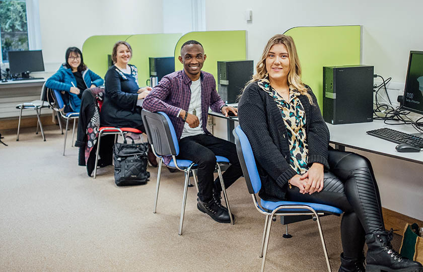 Postgraduate students sitting at computers in MIC computer labs.
