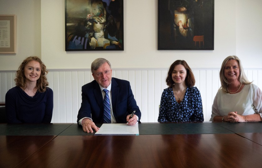  Laura Austin, HEA; Professor Eugene Wall, President of MIC; Dr Jennie Rothwell, HEA; Professor Lorraine McIlrath, Director of EDII at MIC sitting at a table. Professor Wall is signing the principles