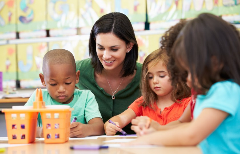 Teacher around table with three students